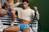 Two models in PUMP! Match Point underwear with a tennis racket beside a courtside bench